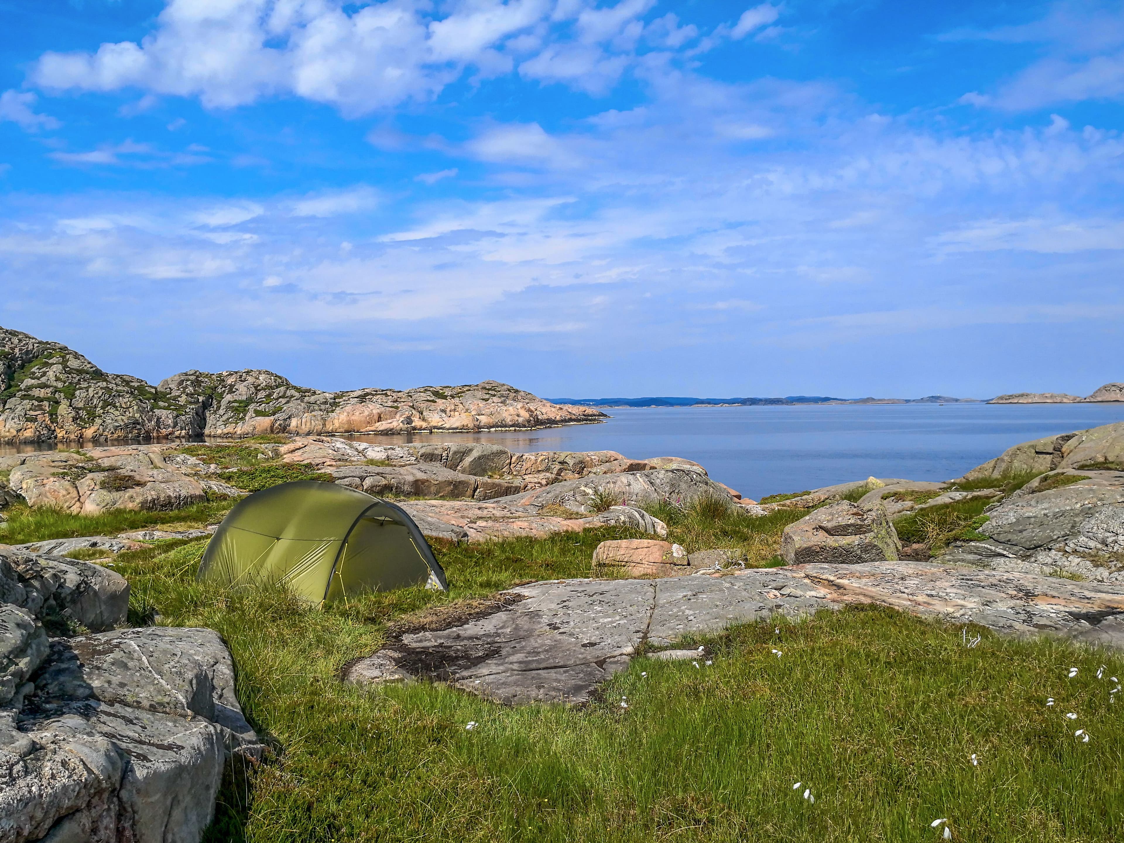 A tent on a rocky Norwegian coast beside the sea