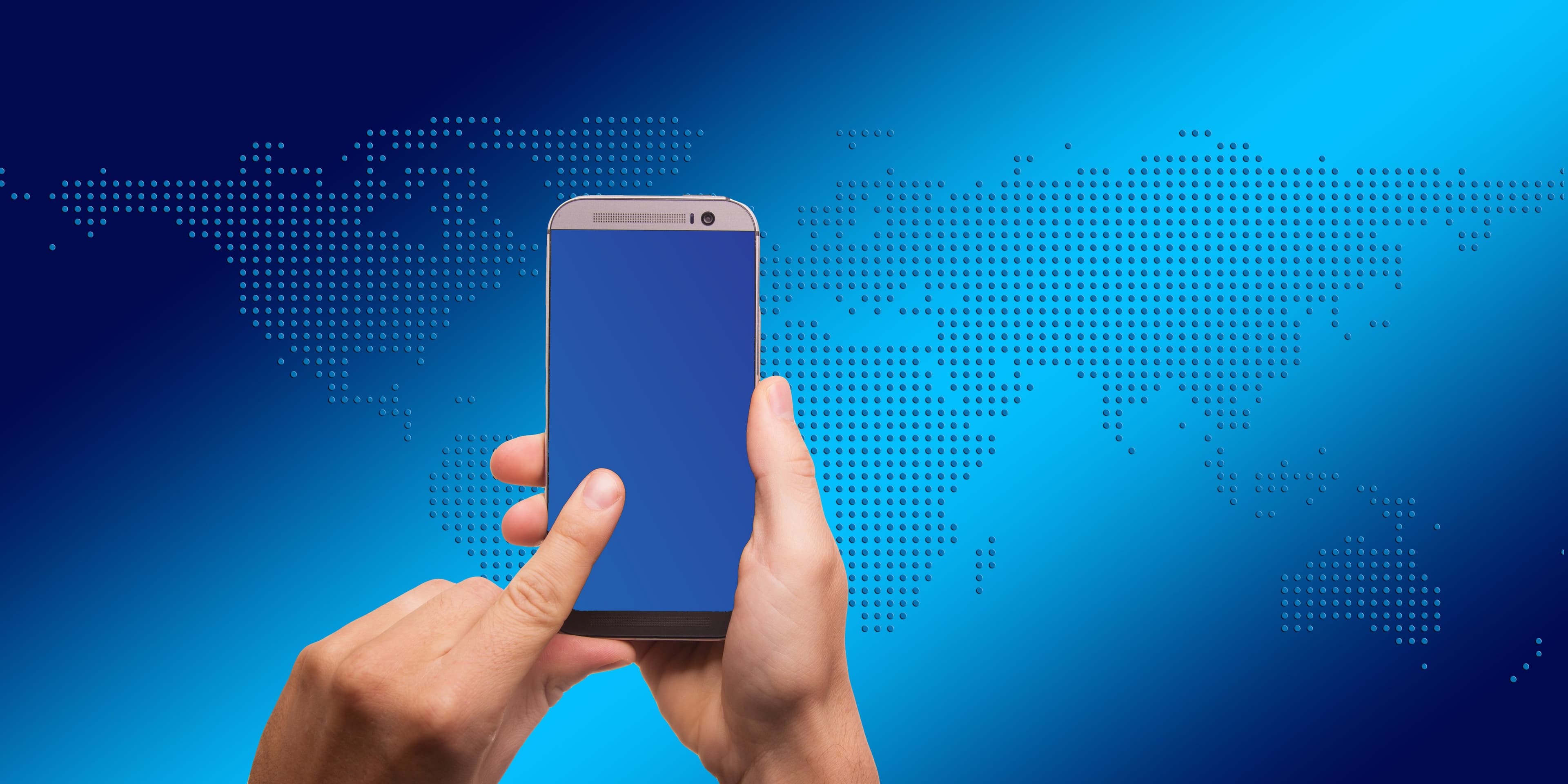 Traveller using a smartphone in front of a world map