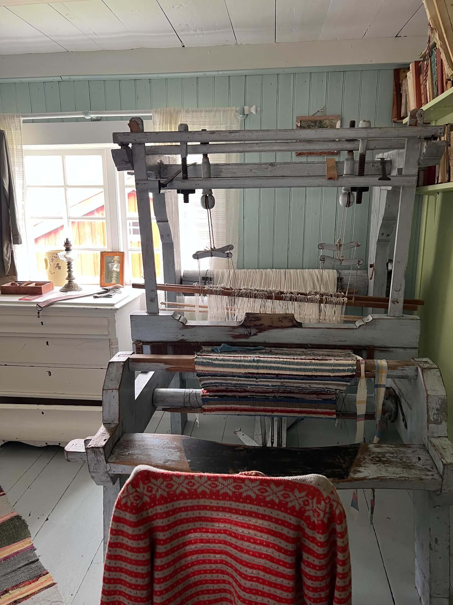 Historic weaving loom with woven textiles in a preserved Helgeland interior