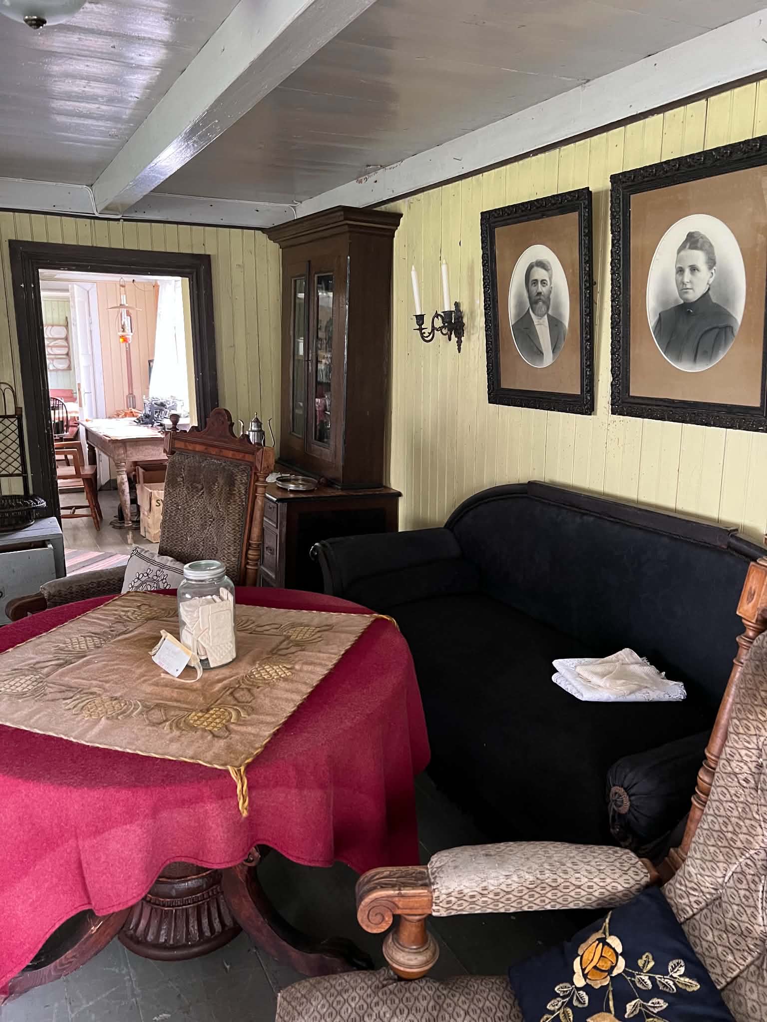 Sitting room with framed portraits and traditional furniture