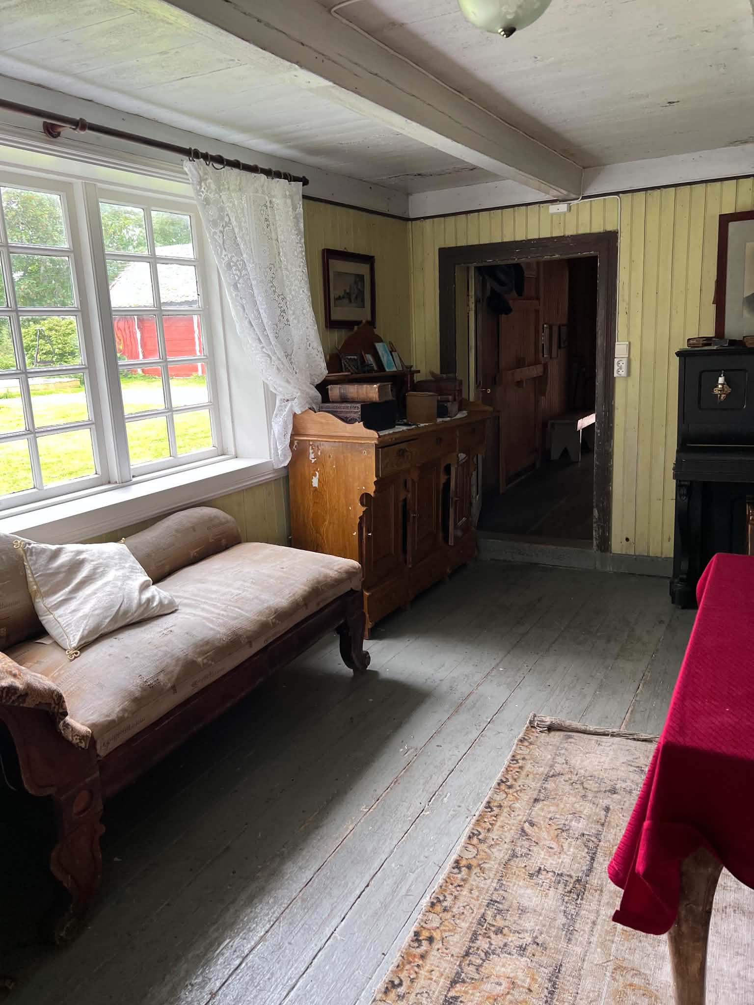 Preserved parlour with traditional furniture beside a coastal window