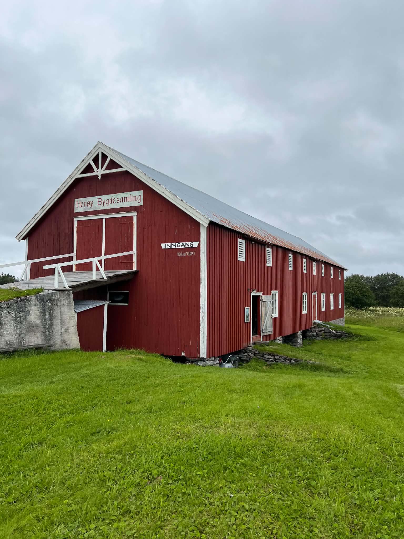 The red timber exterior of Herøy Bygdesamling beneath an overcast sky.