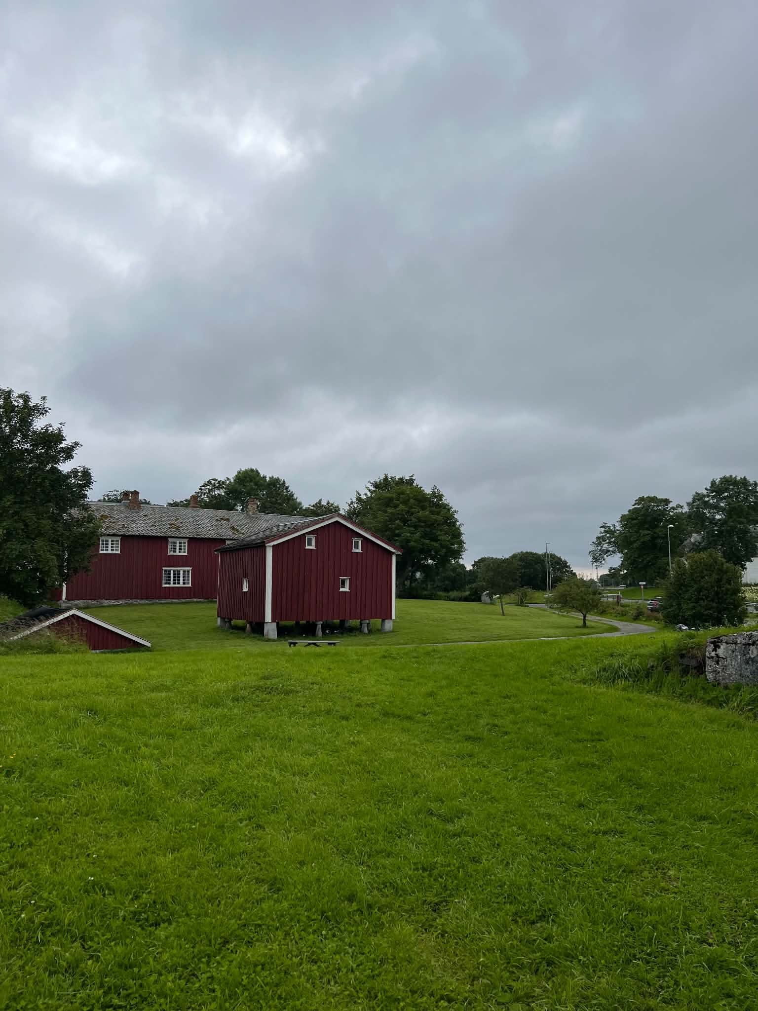 Traditional red farm buildings surrounded by green fields on Herøy.