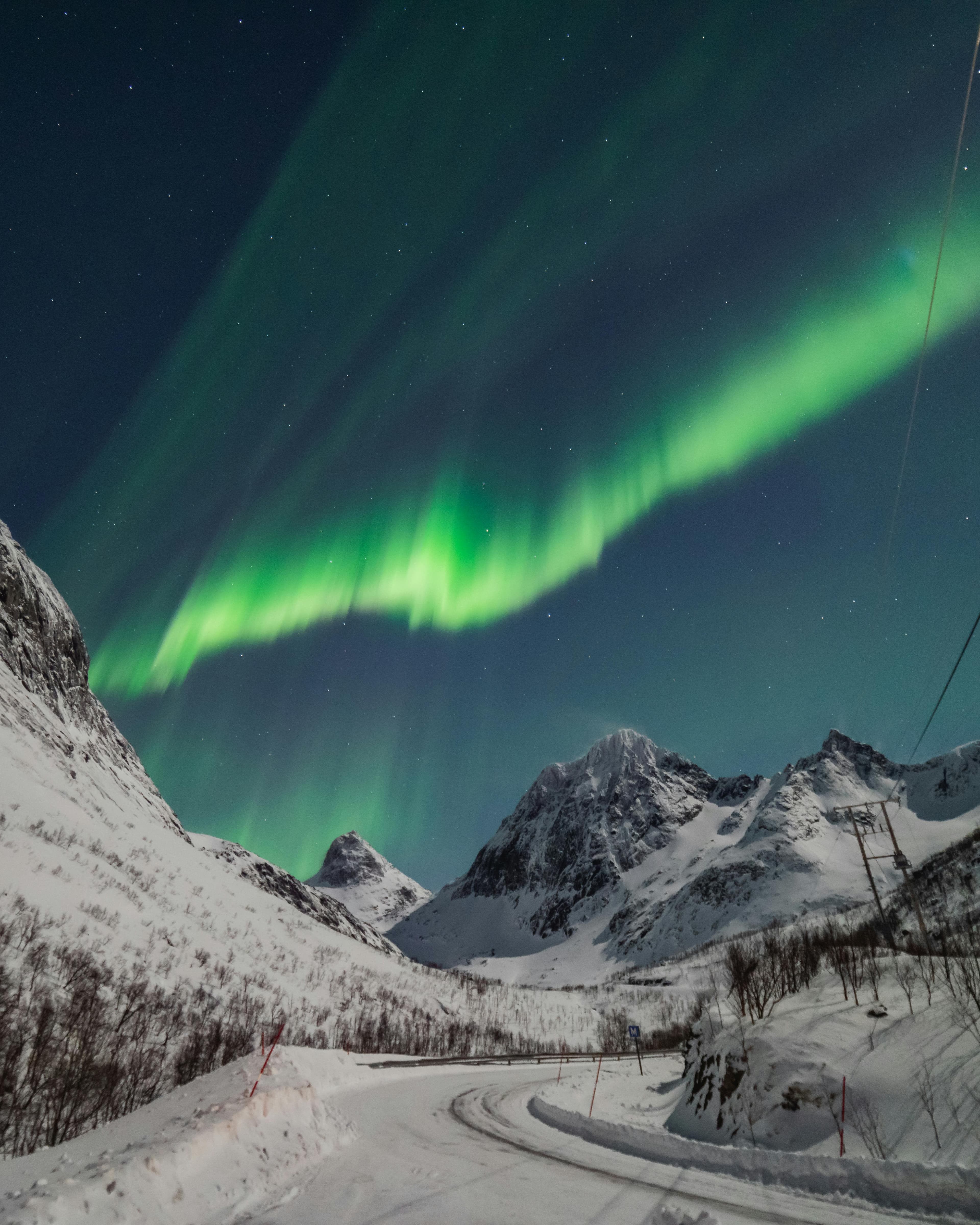 Aurora over snowy mountains near Tromso