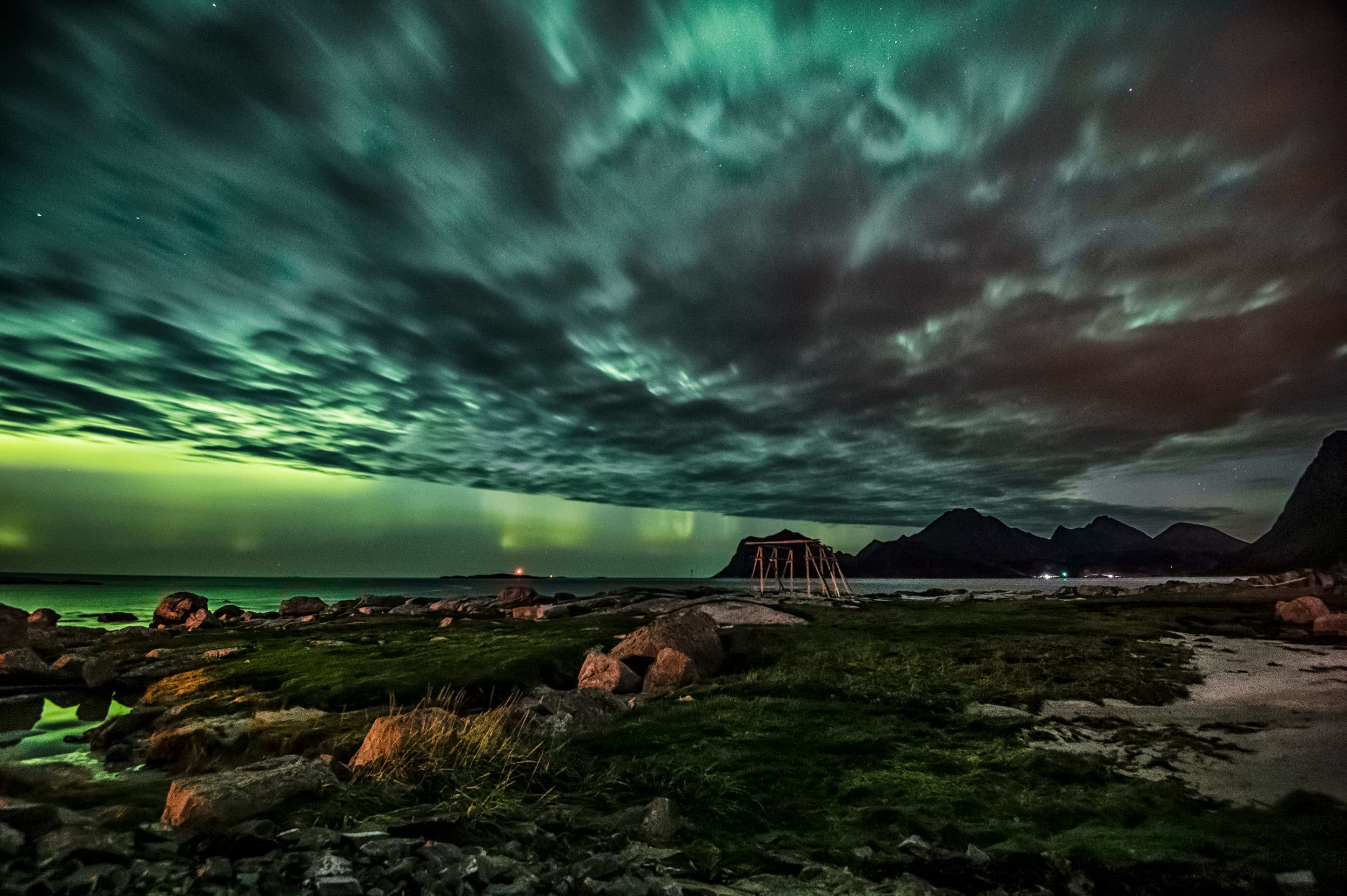 A warm Arctic shoreline at sunset with a dark mountain silhouette
